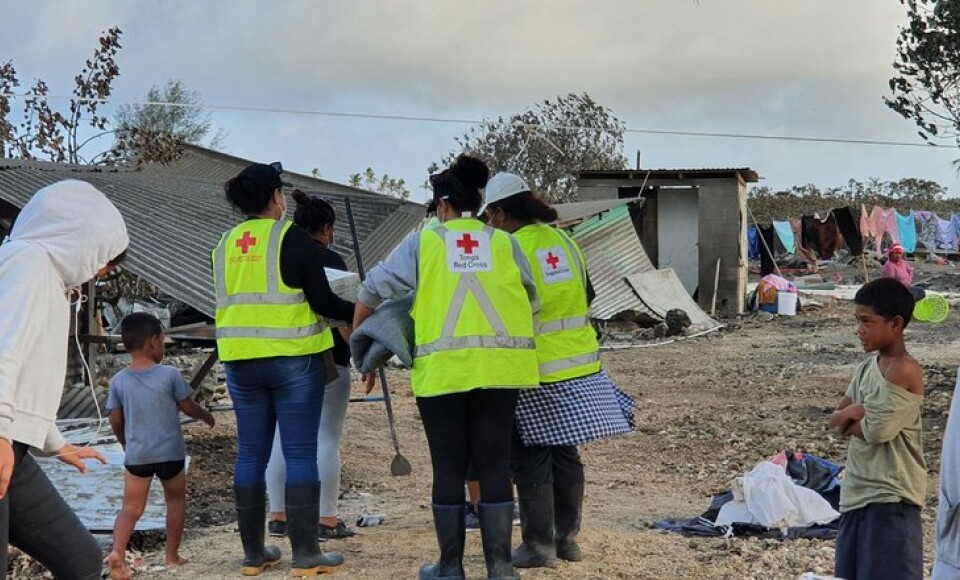 People next to destroyed buildings.