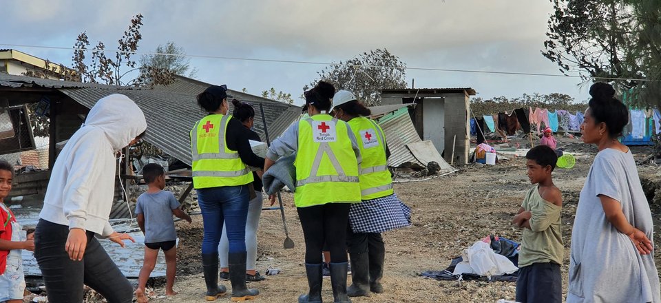 People next to destroyed buildings.