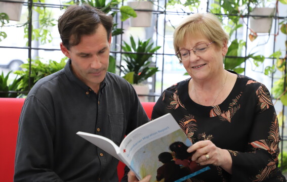 A man and woman looking at a report. 