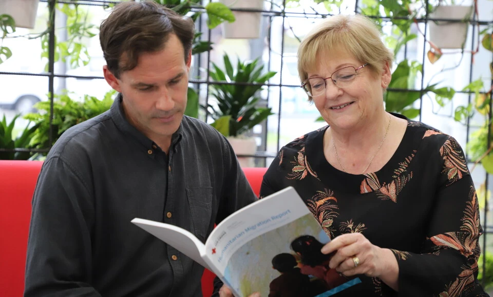 A man and woman looking at a report.