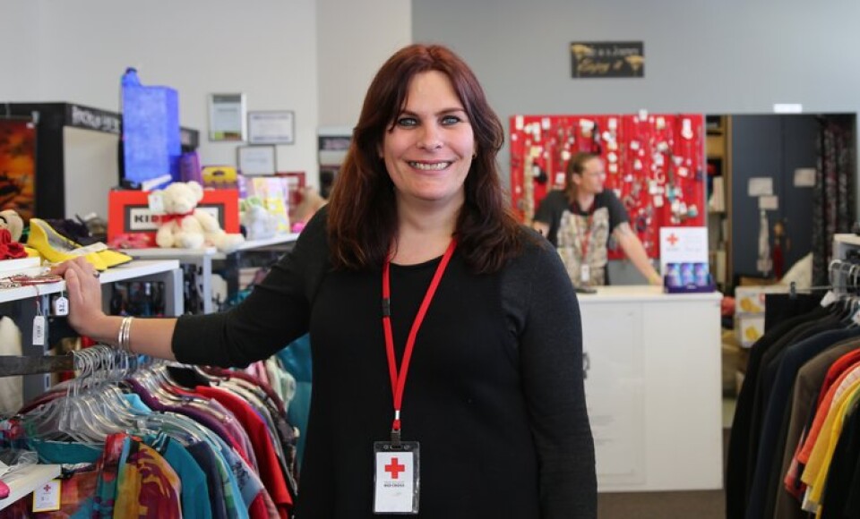 A woman in a retail shop smiling at the camera.