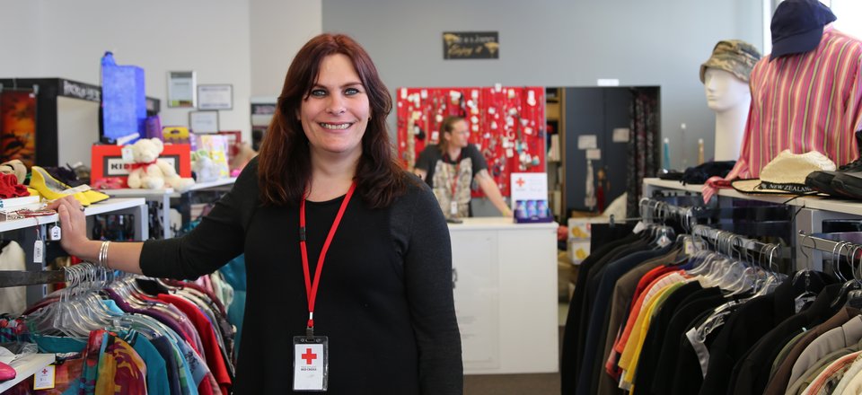 A woman in a retail shop smiling at the camera.