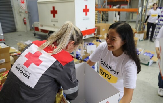 Two women packing supply boxes.