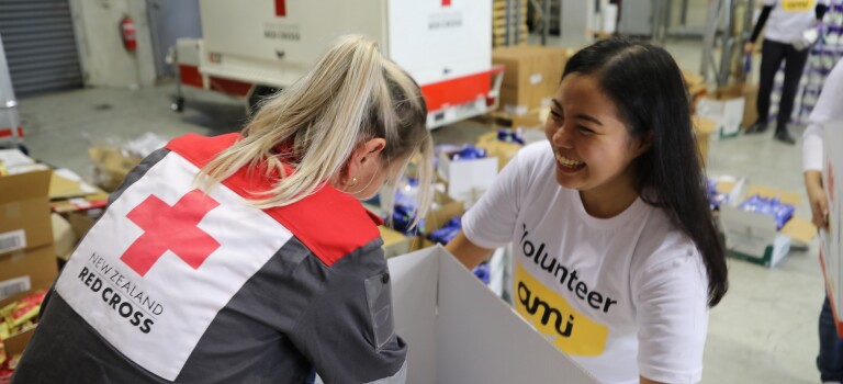 Two women packing supply boxes.