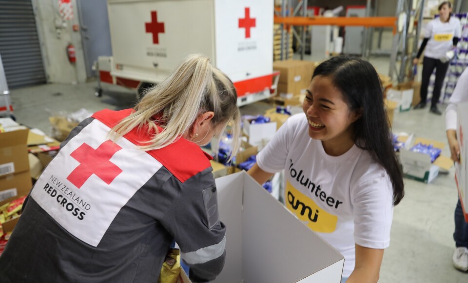 Two women packing supply boxes.