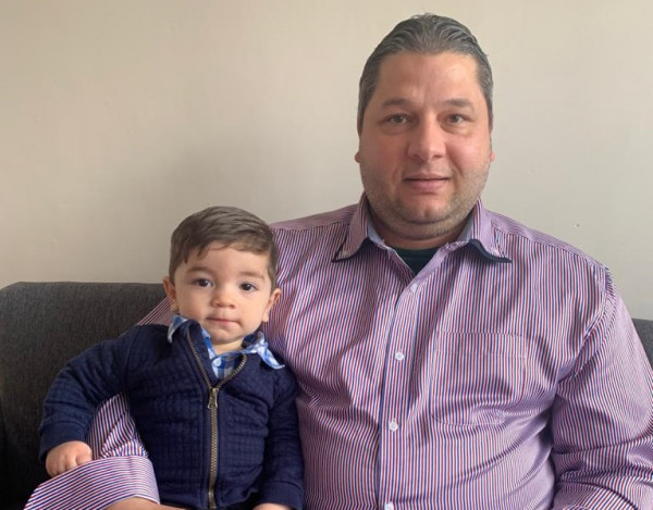 A man sitting with a boy toddler. 