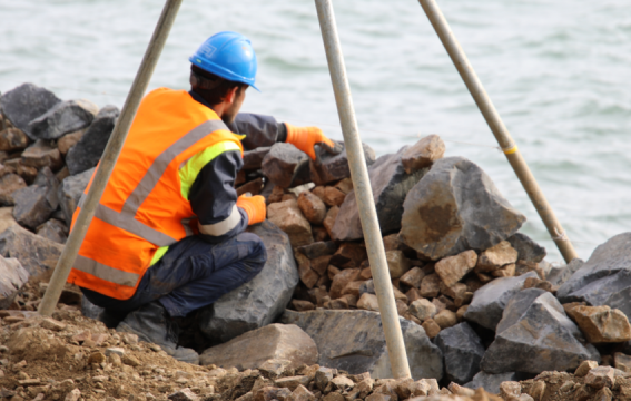 A man working on a seawall. 