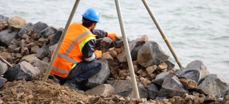 A man working on a seawall. 