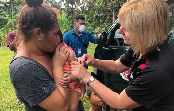 A nurse administering a vaccine to a toddler.