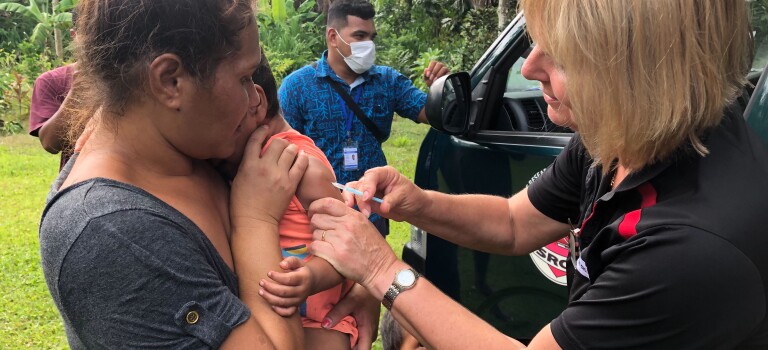 A nurse administering a vaccine to a toddler.