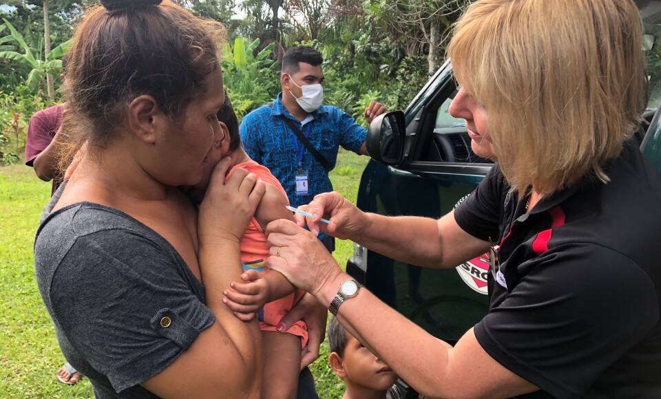 A nurse administering a vaccine to a toddler.