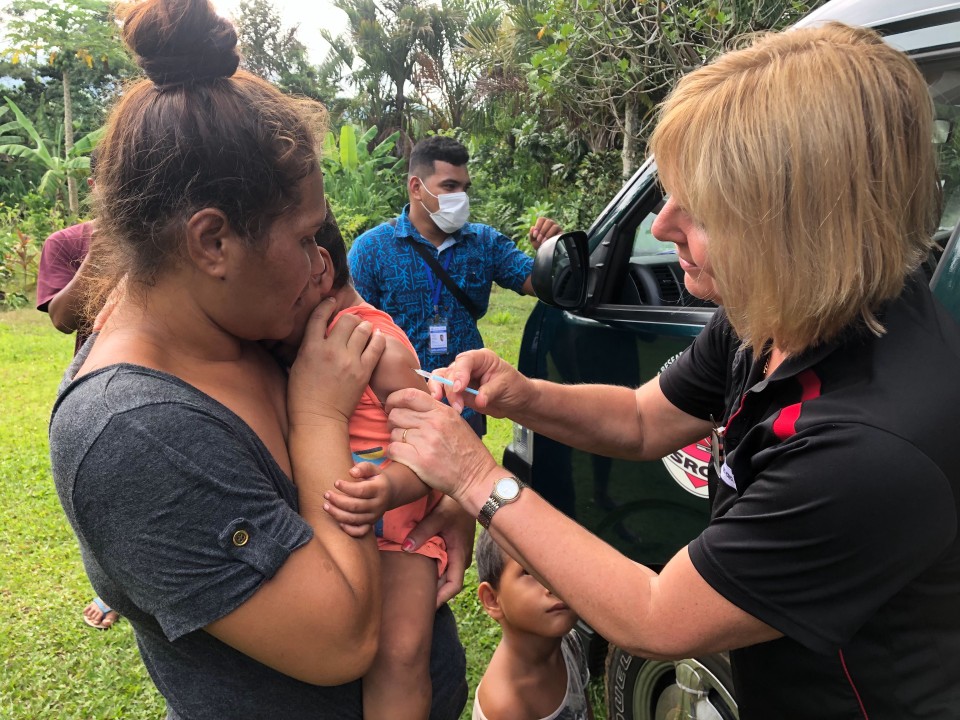 A nurse administering a vaccine to a toddler.