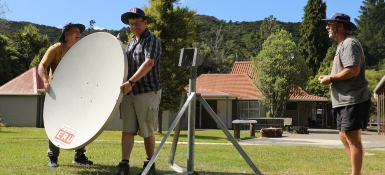 People installing a satellite dish. 