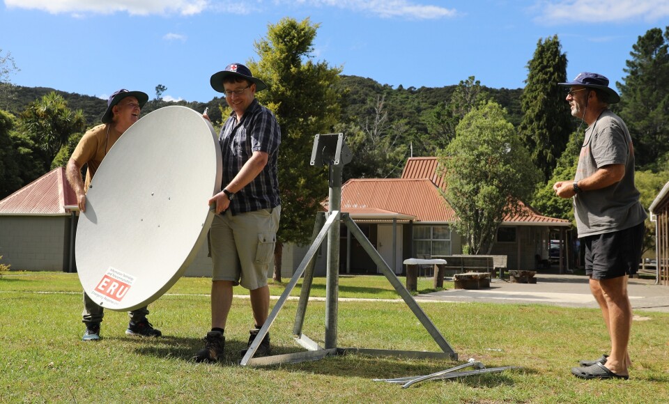 People installing a satellite dish. 