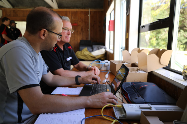 Two men sitting together with a laptop.