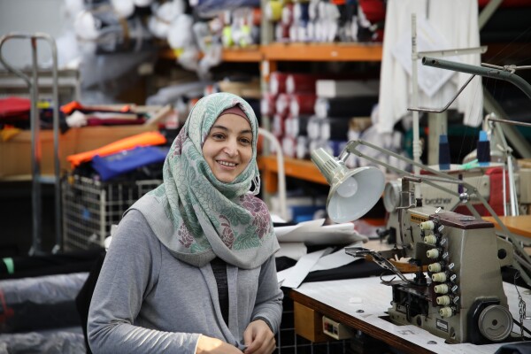 A woman sitting at a sewing machine. 