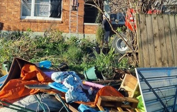 Destroyed belongings outside a house.