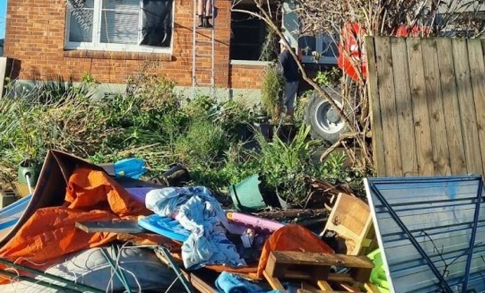 Destroyed belongings outside a house.