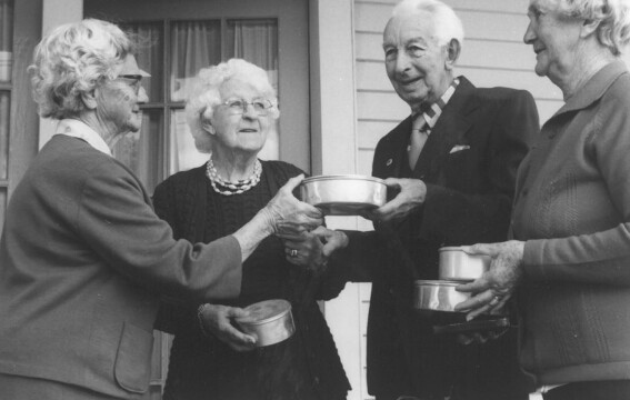 Three older women and an older man with packaged meals.