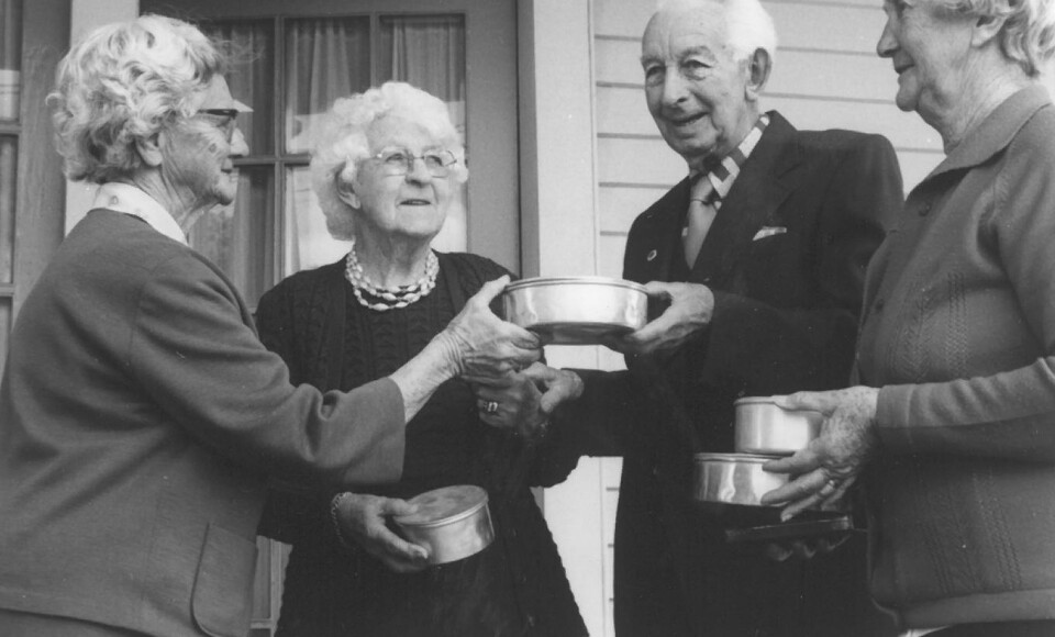 Three older women and an older man with packaged meals.