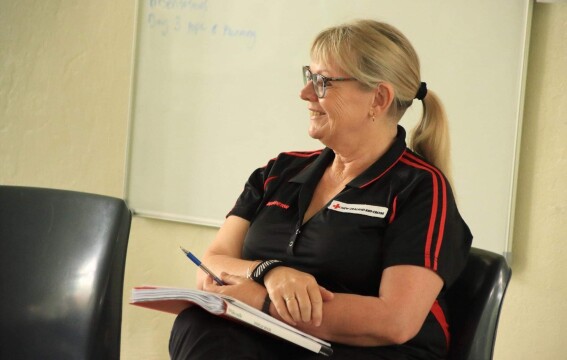 A blonde woman sitting and smiling.