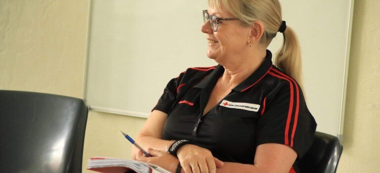 A blonde woman sitting and smiling.