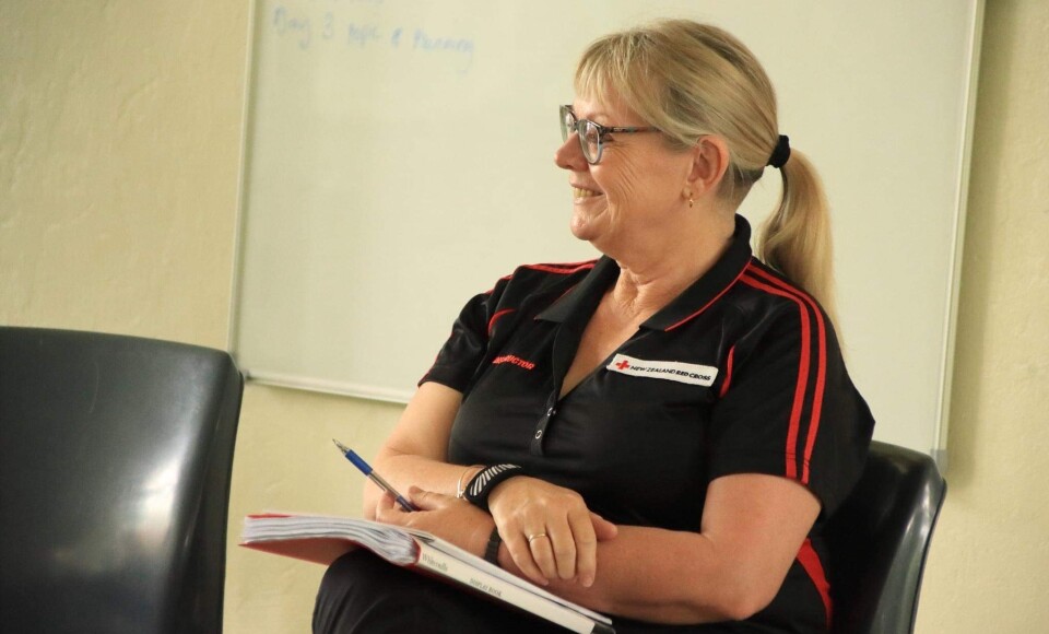 A blonde woman sitting and smiling.