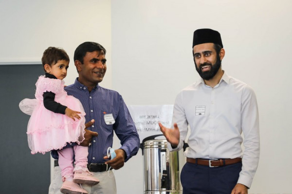 Two men standing together with a girl toddler. 