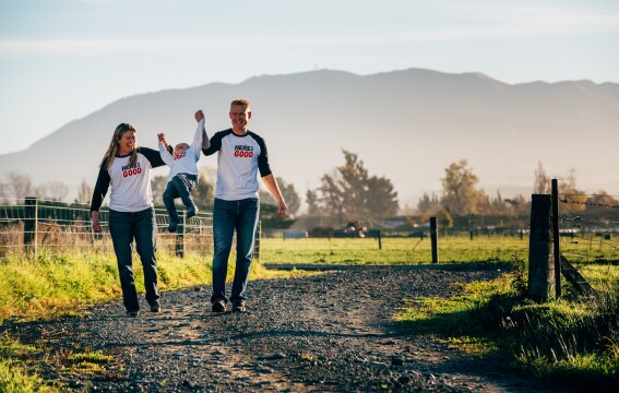 Two adults and a child walking on a rural path