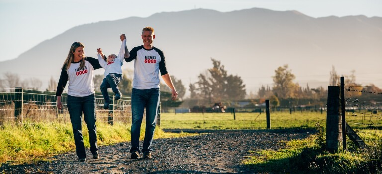 Two adults and a child walking on a rural path