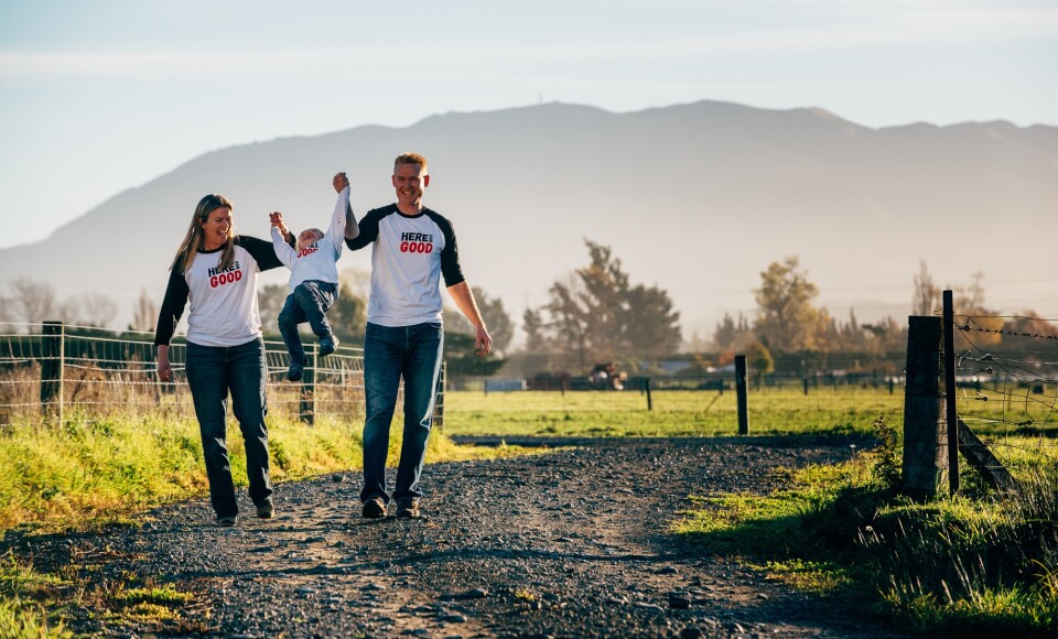 Two adults and a child walking on a rural path