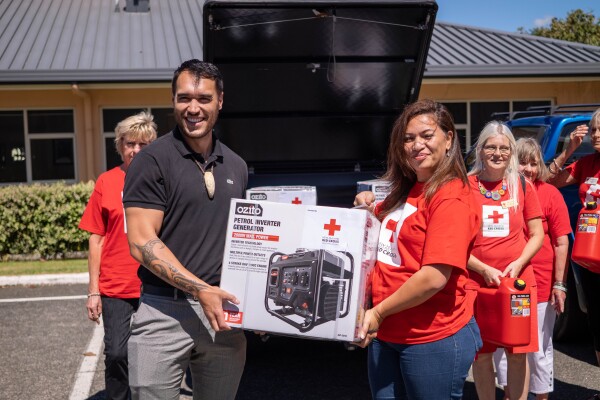A man and a woman holding a generator in a box