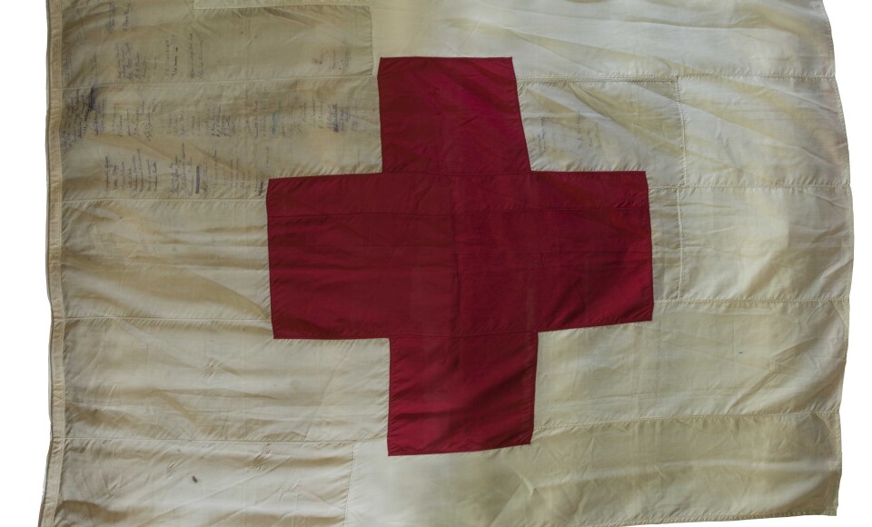 A Red Cross sewn onto a white flag