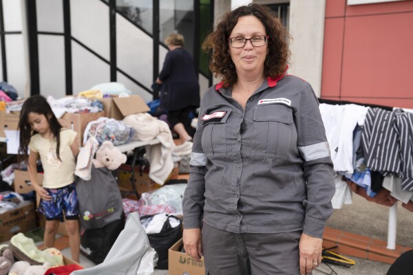 A woman standing in front of boxes of donated clothes
