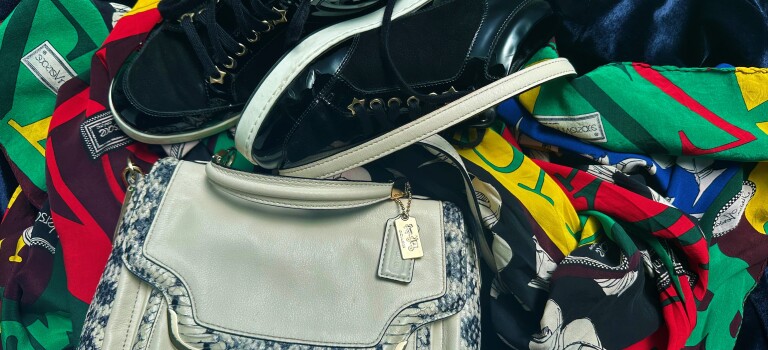 A handbag, sneakers, and a colourful scarf arranged in a display
