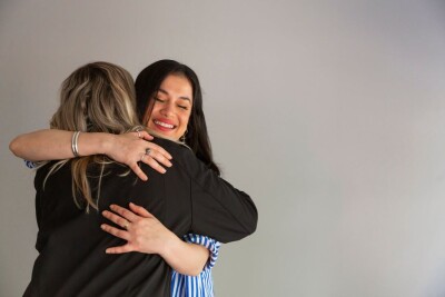 Two women embrace one another after recieving Home Bundles
