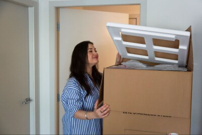 Women carrying a box containing household items