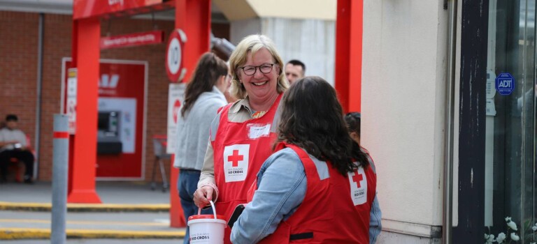 Kerry Nickels wearing a fundraising bib and holding a donation bucket
