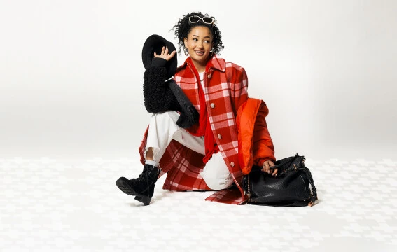 A woman wearing thrifted clothes that are black, white, and red