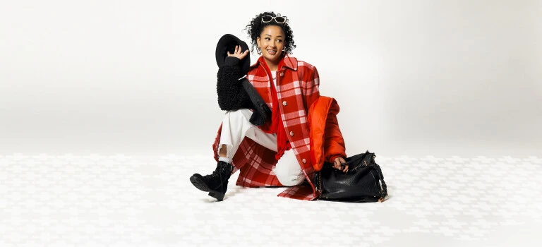 A woman wearing thrifted clothes that are black, white, and red