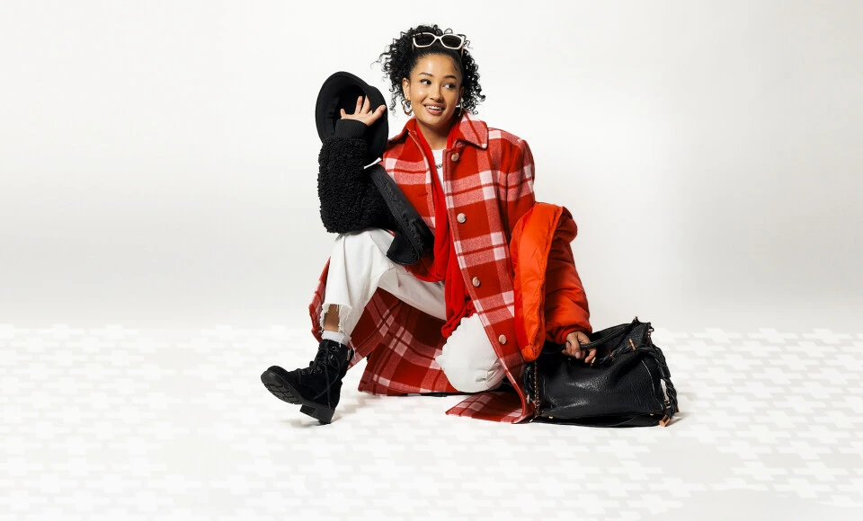 A woman wearing thrifted clothes that are black, white, and red