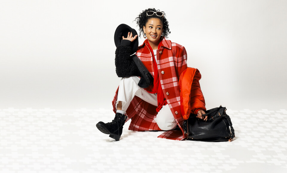 A woman wearing thrifted clothes that are black, white, and red