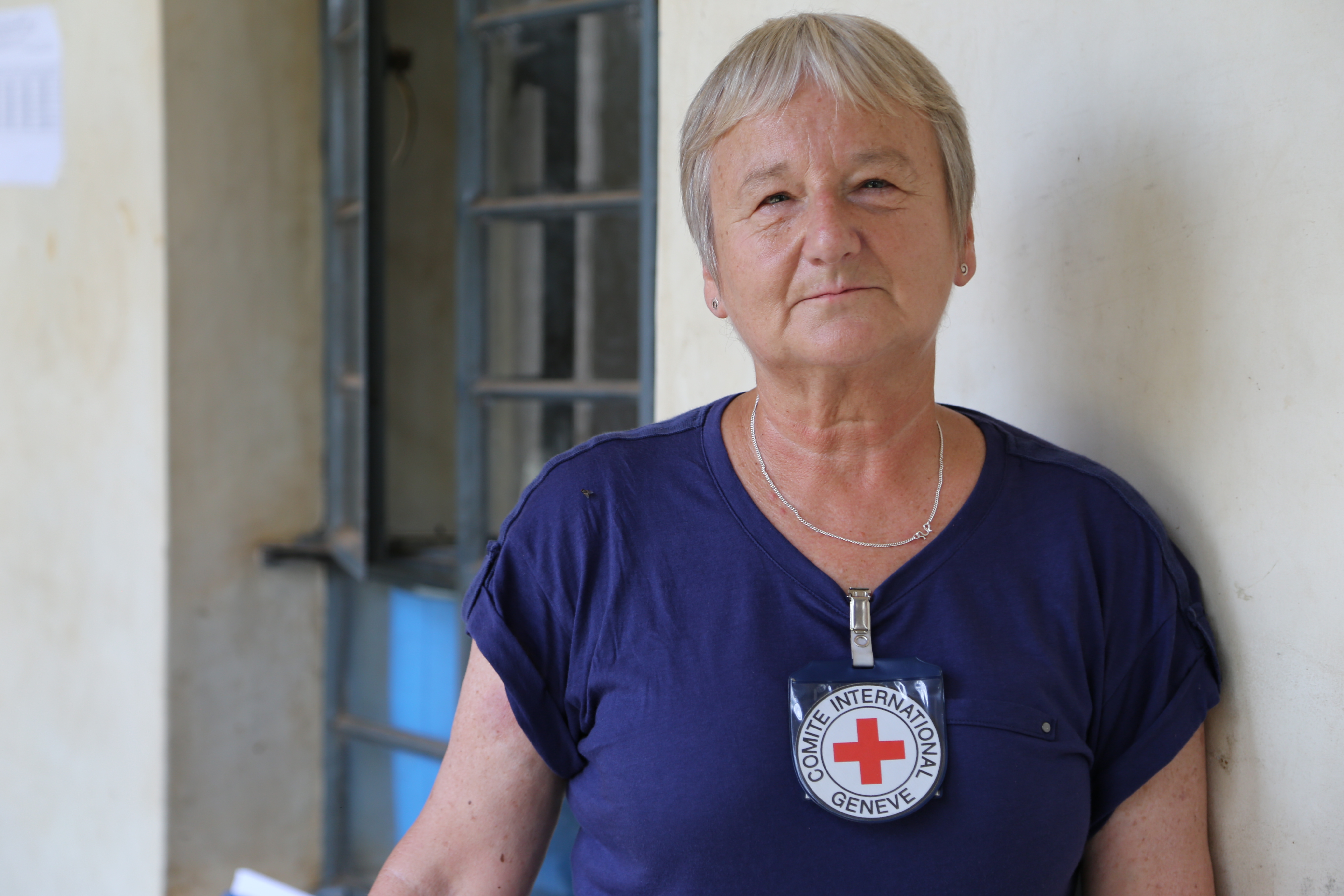 A woman wearing nurses scrubs and an ICRC badge.