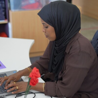 A woman wearing a hijab works in the office.