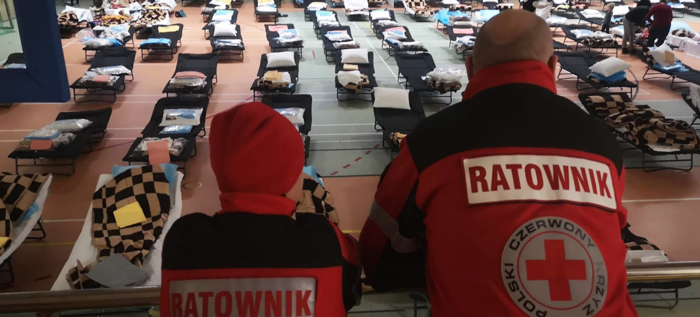 Two people looking in an evacuation centre.