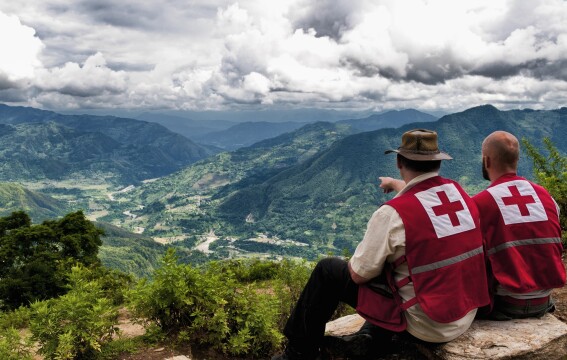 Two people looking out over a settlement.