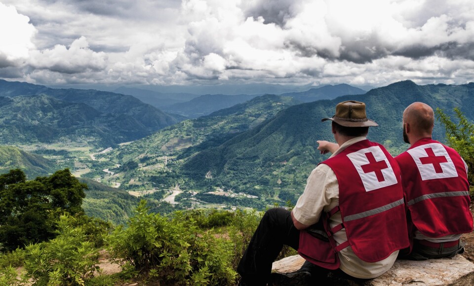 Two people looking out over a settlement.