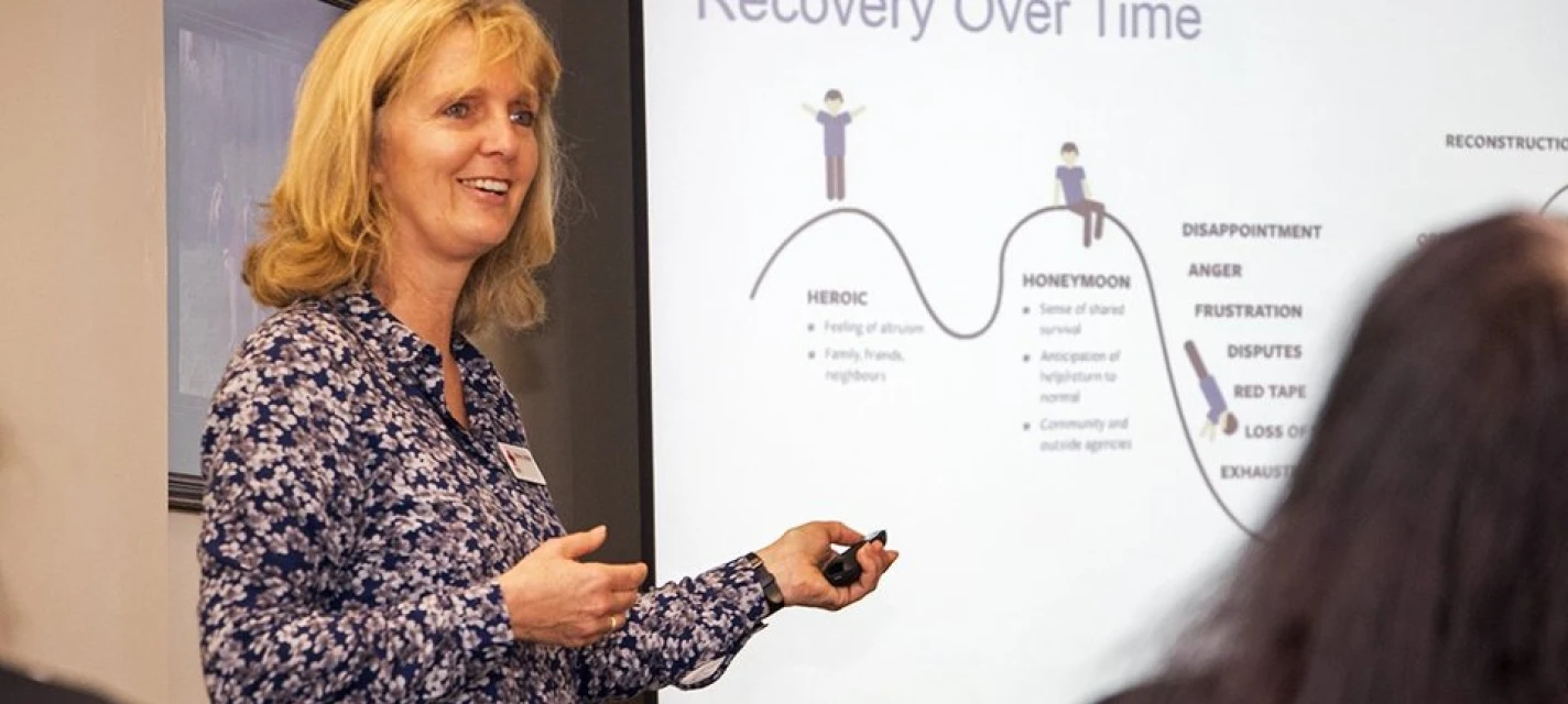 A woman smiles as she gives a presentation