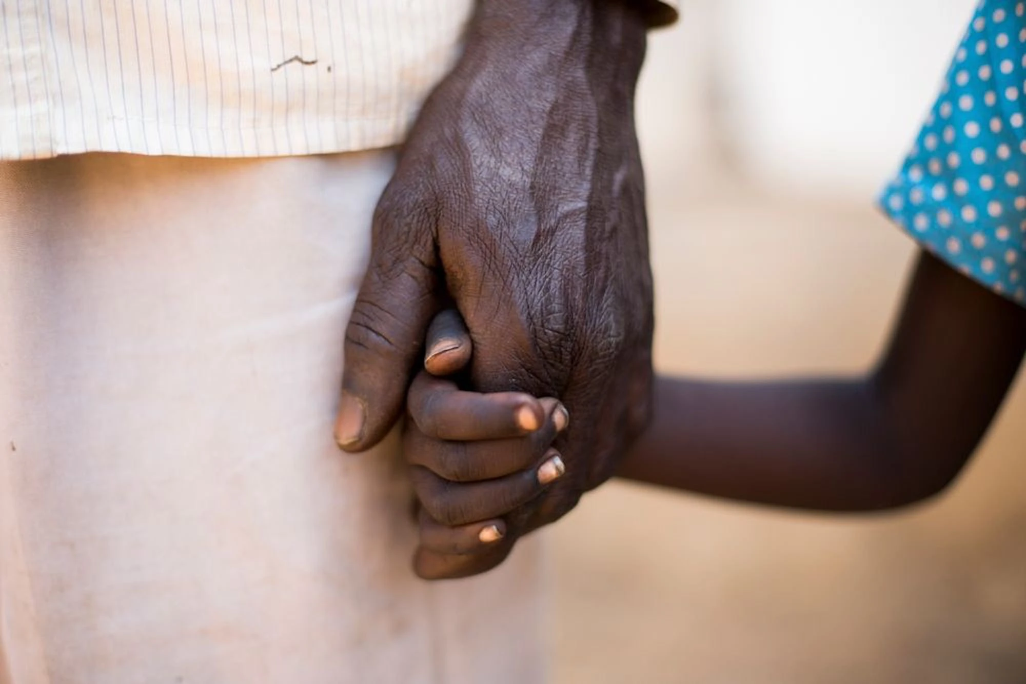 A man holding a child's hand.