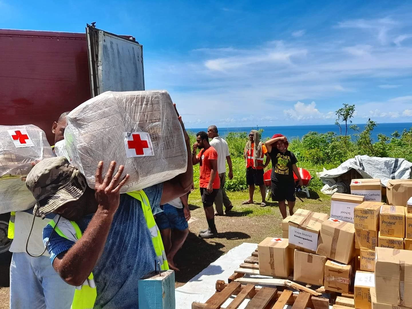 Red Cross volunteers unpack boxes from a truck